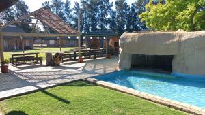 a swimming pool with a fountain in a yard at N18 Chalets in Hartswater