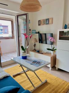 a living room with a glass table and a tv at Plage Cabourg 7 Vue Mer in Cabourg