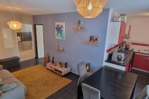 uma sala de estar com uma mesa preta e uma cozinha em Charmant T2 Saint-Leu- Proche lagon et commerces ! em Saint-Leu
