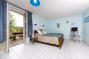 Schlafzimmer mit einem Bett und einer Glasschiebetür in der Unterkunft Une Poule Sur un mur, chambre d'hôte à Soulosse in Soulosse-sous-Saint-Élophe