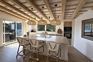 uma cozinha com uma grande ilha de cozinha com cadeiras em Aiguablava Luxury Apartments em Begur