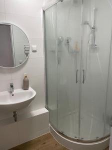 ein weißes Bad mit einer Dusche und einem Waschbecken in der Unterkunft Ferienwohnung mit 2 Zimmer im Belgischen Viertel in Köln