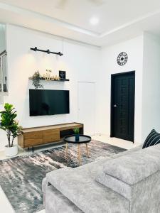 a living room with a couch and a flat screen tv at Anjung Rindu Homestay (Kuala Terengganu, UMT, UniSZA) in Kuala Terengganu