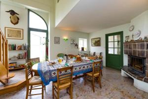 comedor con mesa, sillas y chimenea en Une Poule Sur un mur, chambre d'hôte à Soulosse en Soulosse-sous-Saint-Élophe