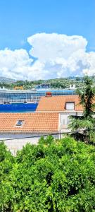 a building with a red roof and some trees at APARTMENT LEA BAYVIEW in Dubrovnik