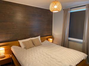 - une chambre avec un grand lit et un mur en bois dans l'établissement Fräsch och fin 2:a. Gångavstånd till Strömstads Centrum, à Strömstad