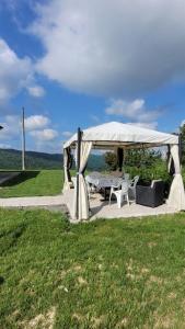 einen Pavillon mit einem Tisch und Stühlen auf einem Feld in der Unterkunft Casa vacanze in Mombarcaro