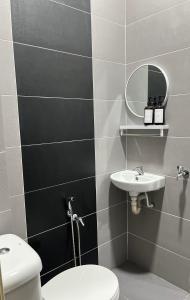 W łazience znajduje się toaleta, umywalka i lustro. w obiekcie Anjung Rindu Homestay (Kuala Terengganu, UMT, UniSZA) w mieście Kuala Terengganu
