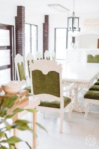 biała jadalnia z białym stołem i krzesłami w obiekcie Casa Don Julian Guesthouse w mieście Bais
