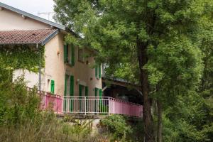 una casa con un balcón rosa y árboles en Jolie vache déguisée en fleurs, chambre d'hôte à Soulosse en Soulosse-sous-Saint-Élophe