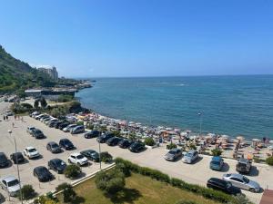 a parking lot with cars parked next to the ocean at Hotel Ferrara in Durrës