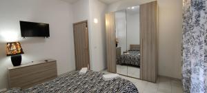 - une chambre d'hôtel avec un lit et un miroir dans l'établissement Janara - Mura Longobarde, à Bénévent