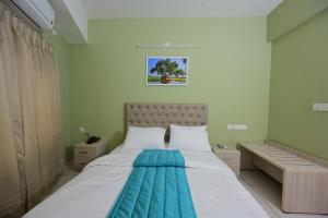 ein Schlafzimmer mit einem großen weißen Bett in einem Zimmer in der Unterkunft RG's The 4th Residency in Thiruvananthapuram