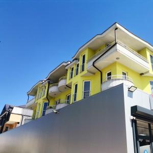 een geel gebouw met een hek ervoor bij Egnatia Apartments in Struga