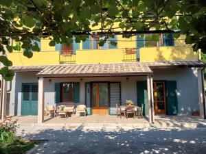 卡瓦德蒂雷尼的住宿－Lanovella，黄色的房子前面设有桌椅
