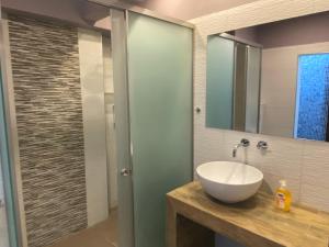 une salle de bain avec un lavabo et une douche en verre dans l'établissement Rotonda City Center, à Thessalonique 10 autres photos