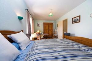 1 dormitorio con 1 cama con edredón azul y blanco en Dessine moi un mouton, chambre d'hôte à Soulosse, en Soulosse-sous-Saint-Élophe