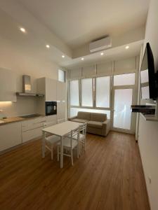 Una cocina y una sala de estar con una mesa y un sofá. en JESOLO SPIAGGIA HOLIDAY, en Lido di Jesolo 8 fotos más