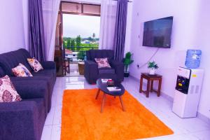 - un salon avec deux canapés et une télévision dans l'établissement Volume view Apartments, à Mombasa