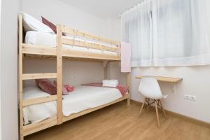 sypialnia z 2 łóżkami piętrowymi i biurkiem w obiekcie Balcon del Atardecer w mieście Barbate