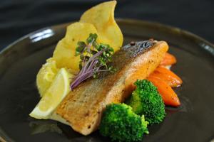a plate of food with fish and vegetables on it at Vannee Golden Sands Beachfront Resort in Haad Rin