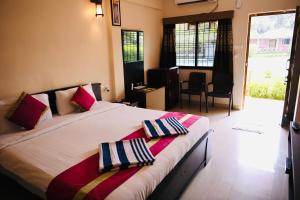 a bedroom with a bed with two pillows on it at Lighthouse Waterpark and Resort in Mansar