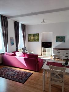 ein Wohnzimmer mit einem rosa Sofa und einem Tisch in der Unterkunft Ferienwohnung Barfly in Traben-Trarbach
