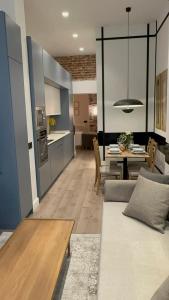 cocina y sala de estar con sofá y mesa en APARTAMENTOS ALCALA, en Madrid