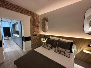 a living room with a couch and a brick wall at APARTAMENTOS ALCALA in Madrid