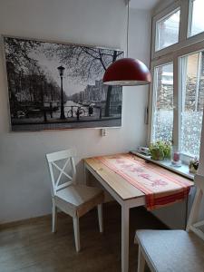 a dining room table with a chair and a picture on the wall at Ferienwohnung Barfly in Traben-Trarbach