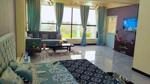 uma sala de estar com um sofá e uma mesa em Motorway Majesty Suites Islamabad - Near Islamabad International Airport and Motorway em Islamabad