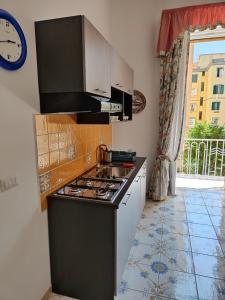 eine Küche mit einem Herd, einem Waschbecken und einem Fenster in der Unterkunft The House Of The Sunbeam in Neapel