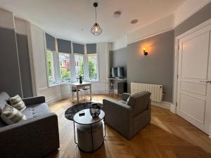 a living room with two couches and a table at Luxury apartment stay in Cardiff