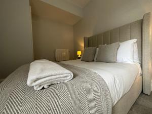 a bedroom with a bed with a white blanket on it at Luxury apartment stay in Cardiff