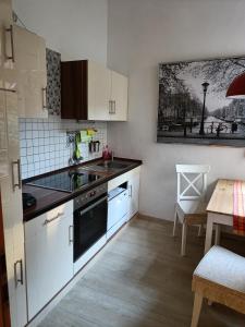 a kitchen with white cabinets and a black stove top oven at Ferienwohnung Barfly in Traben-Trarbach