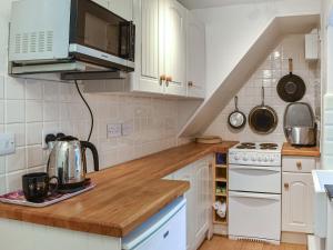 a kitchen with white cabinets and a counter top at Tyn Y Berth in Talsarnau