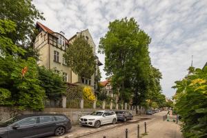 a row of cars parked on a street with buildings at Studio Baltic in Sopot