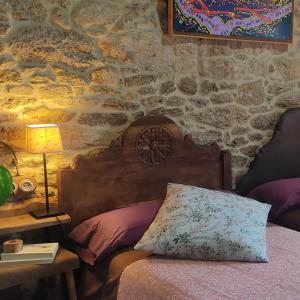 a bedroom with a bed and a table with a lamp at WITERICUS hospedaxe in Guitiriz