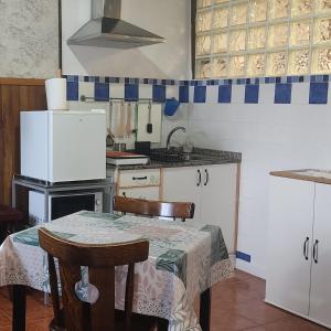 a kitchen with a table and a refrigerator at WITERICUS hospedaxe in Guitiriz