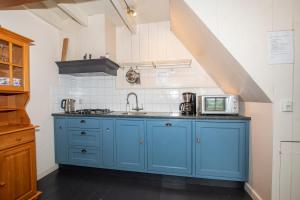 a kitchen with a blue cabinet and a microwave at Hoeve Suydeinde in Aarlanderveen