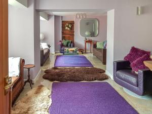 ein Wohnzimmer mit lila Teppichböden und lila Teppichen in der Unterkunft Coach House in Ashford
