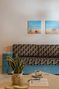 a living room with a couch and a table with a plant at Molos Bay Hotel in Kissamos