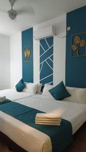 a large bed in a room with blue walls at Olive Hotel in Johor Bahru