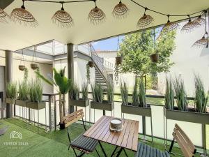 a patio with a table and chairs and potted plants at ღ La Terrasse Baïa • Parking & Wi-Fi in Toulouse