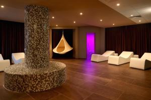 a lobby with white chairs and a column with a purple light at Remisens Hotel METROPOL in Portorož