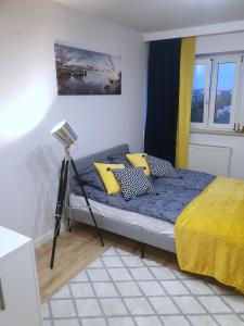 een slaapkamer met een bed met gele kussens bij APARTAMENT AIRPORT 132 in Warschau