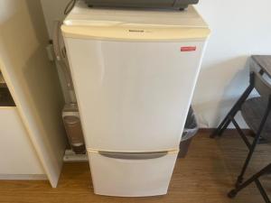 a white refrigerator with a computer on top of it at Morinomiya Flat 森ノ宮フラット in Osaka