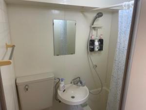 a bathroom with a toilet and a sink and a mirror at Morinomiya Flat 森ノ宮フラット in Osaka