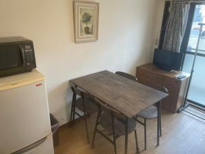 a kitchen with a table and chairs and a microwave at Morinomiya Flat 森ノ宮フラット in Osaka +7 photos