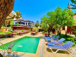 a row of lounge chairs next to a swimming pool at Necip Bey Konağı in Antalya